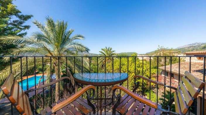 Ein Tisch und Stühle auf einem Balkon mit Blick auf einen Pool