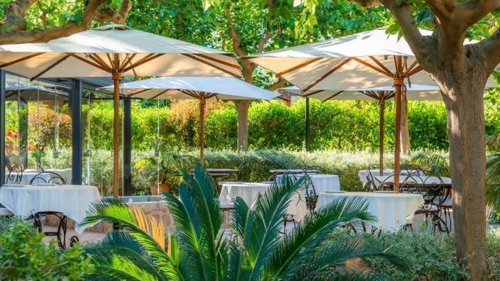 Ein Restaurant mit weißen Tischen und Stühlen und weißen Sonnenschirmen