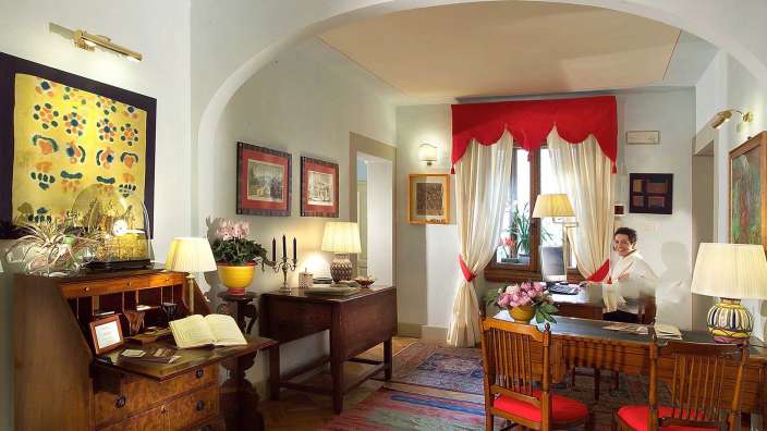 Eine Frau sitzt an einem Schreibtisch in einem Wohnzimmer