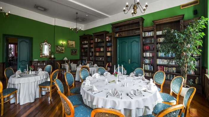 Ein Esszimmer mit weißen Tischen und blauen Stühlen