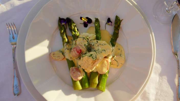 Ein weißer Teller mit einem Salat aus Spargel und Tomaten