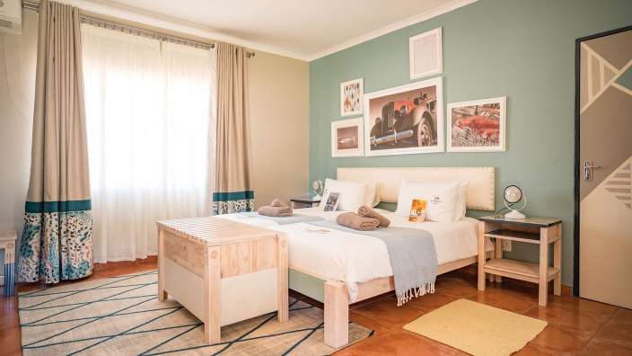 Ein Schlafzimmer mit zwei Betten und Bildern an der Wand