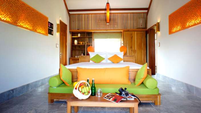 Ein Schlafzimmer mit einem großen Bett und einer grünen Couch