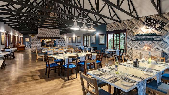 Ein Restaurant mit vielen Tischen und Stühlen und einem Schild an der Wand , das unsere Tasse sagt