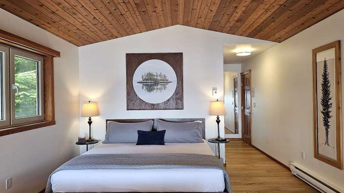 Ein Schlafzimmer mit einem Bett und einem Gemälde an der Decke