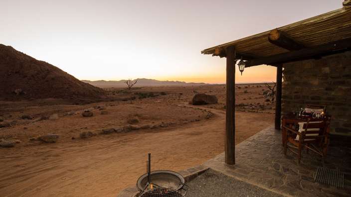 Ein Tisch und Stühle auf einer Veranda mit Blick auf die Wüste