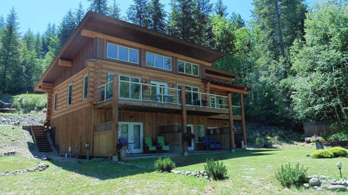 Ein großes Holzhaus mit vielen Fenstern inmitten eines Waldes