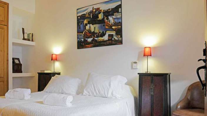 Ein Schlafzimmer mit zwei Betten und einem Gemälde an der Wand