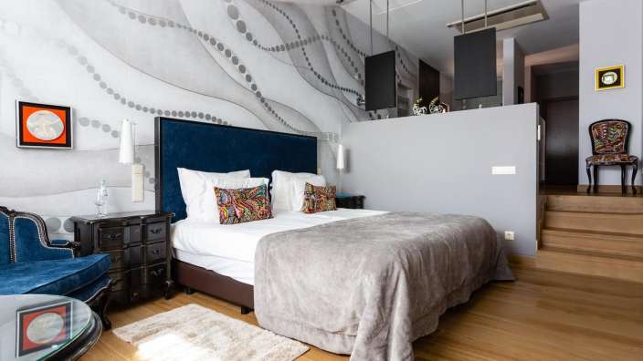 Ein Schlafzimmer mit einem großen Bett und einem blauen Stuhl