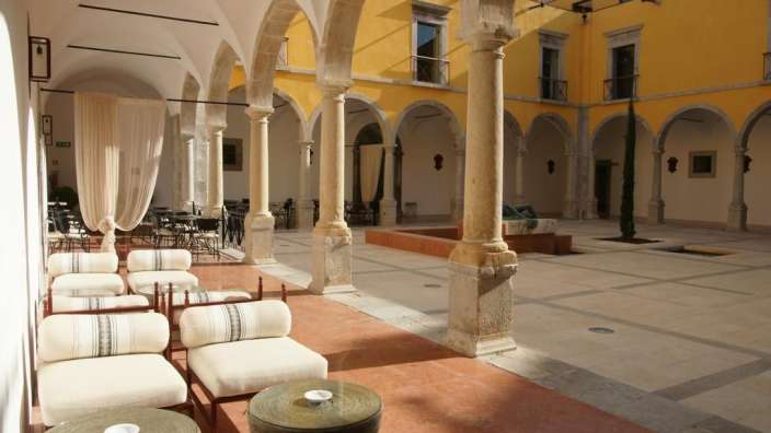 Eine Reihe weißer Stühle und Tische in einem Hof