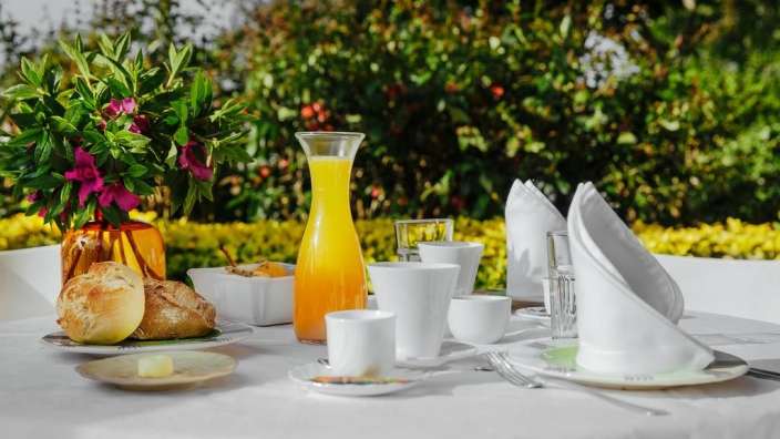 Ein Tisch mit einer Flasche Orangensaft und einer Vase mit Blumen darauf