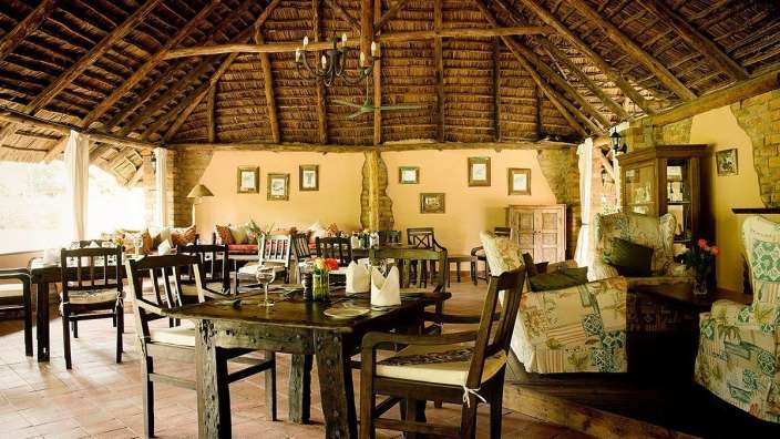 Ein Esszimmer mit Tisch und Stühlen und einem Strohdach
