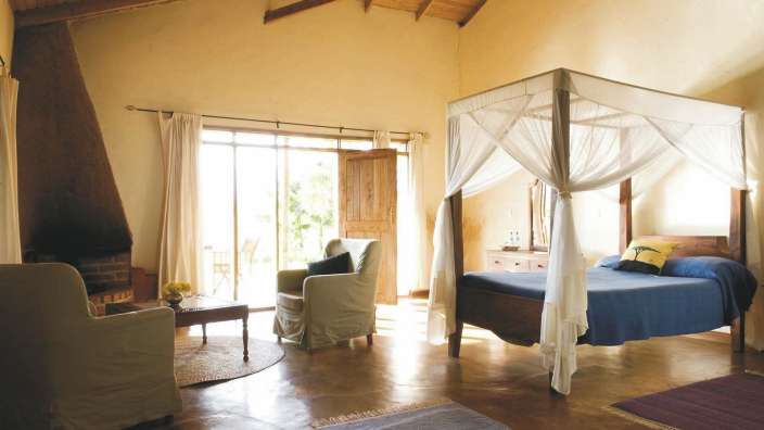 Ein Zimmer mit einem Himmelbett und einem Kamin