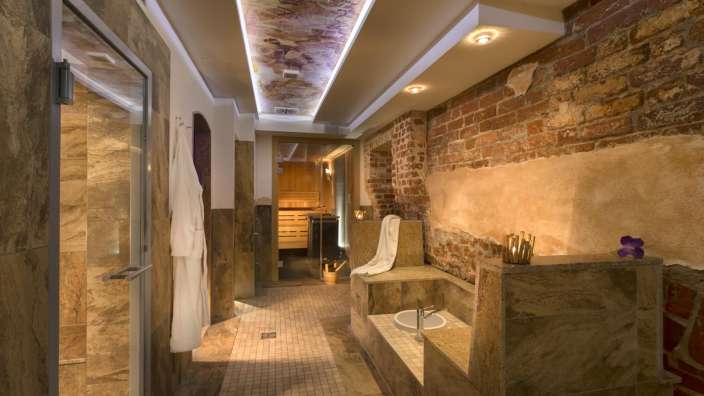 Ein Badezimmer mit Backsteinwänden und einem weißen Bademantel