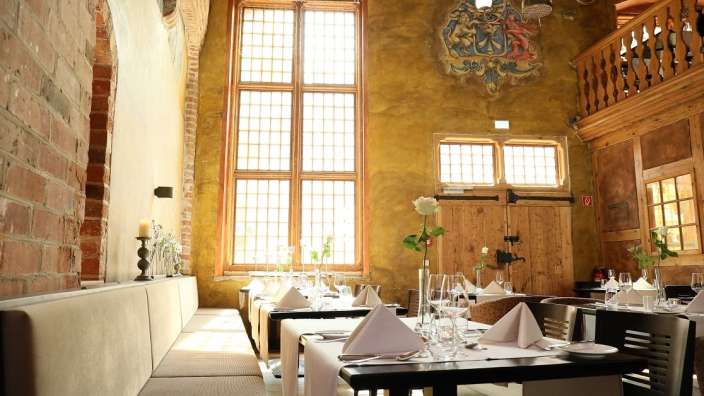 Ein Esszimmer mit vielen Tischen und Stühlen und einem großen Fenster