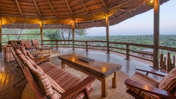 Ein Holzdeck mit Stühlen und einem Tisch darauf