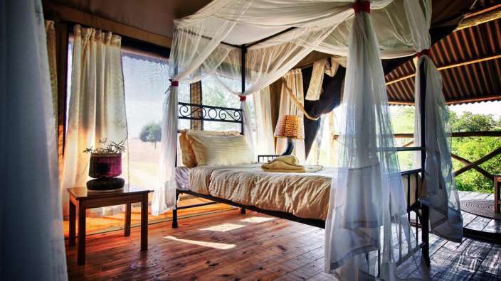 Ein Schlafzimmer mit einem Himmelbett und weißen Vorhängen