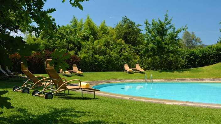 Liegestühle stehen um einen großen Swimmingpool