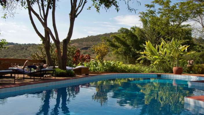 Eine Person liegt auf einem Stuhl in der Nähe eines Swimmingpools