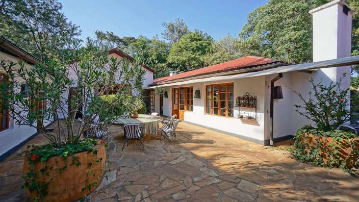 Ein weißes Haus mit einem Tisch und Stühlen davor