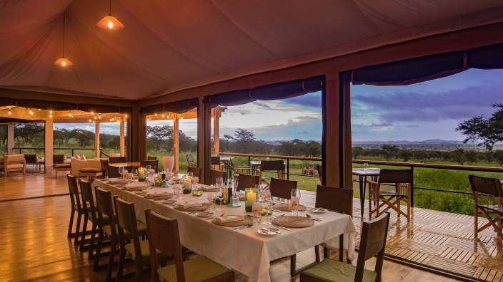 Ein Tisch mit Tellern und Stühlen in einem Zelt