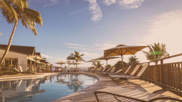 Liegestühle und Sonnenschirme umgeben einen großen Swimmingpool