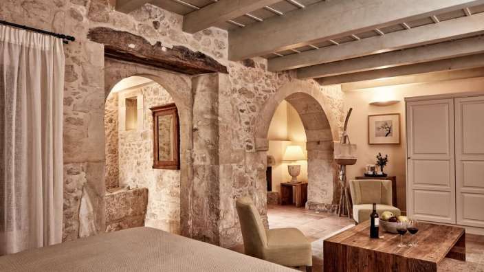 Ein Zimmer mit einem Bett und einem Tisch mit einer Flasche Wein darauf