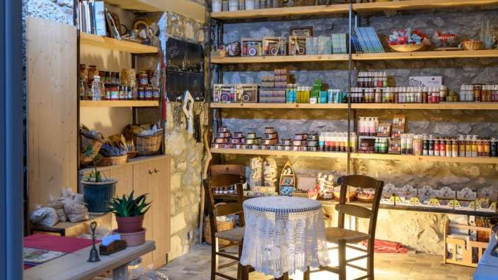 Ein Raum mit einem Tisch und Stühlen und Regalen mit Produkten