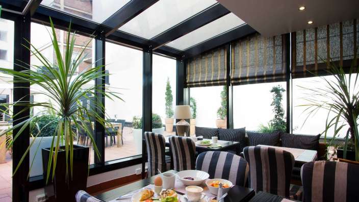 Ein Esszimmer mit einem Tisch und Stühlen und vielen Fenstern