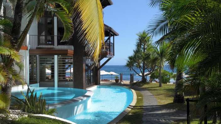 Ein großer Pool in der Nähe eines Hauses mit Blick aufs Meer