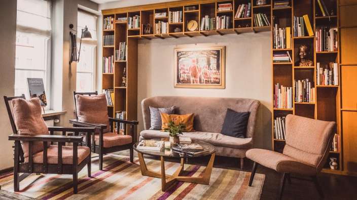 Ein Wohnzimmer mit Couch und Stühlen und Bücherregalen