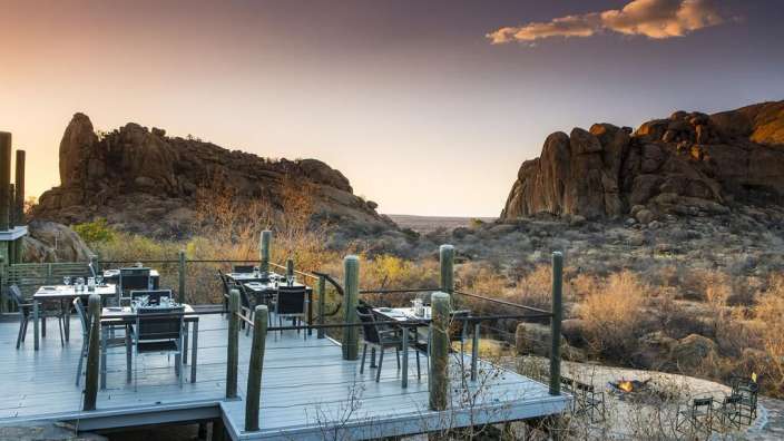 Eine Terrasse mit Tischen und Stühlen mit einem Berg im Hintergrund