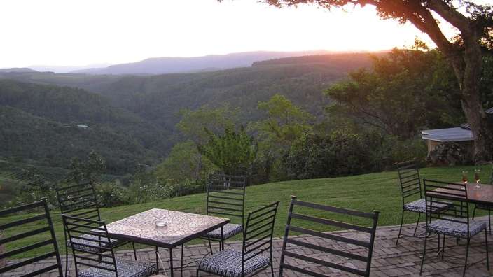 Ein Tisch und Stühle auf einer Terrasse mit Blick auf die Berge