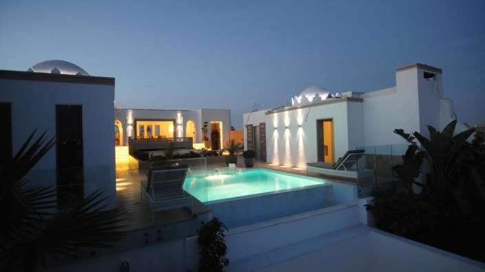 Ein weißes Haus mit einem großen Pool davor