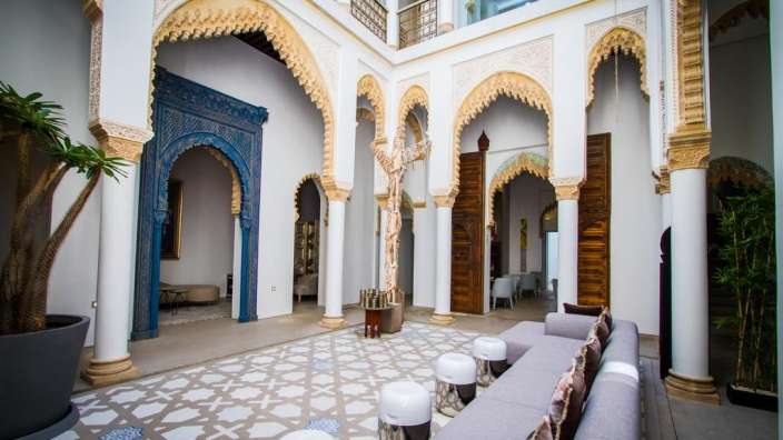 Ein Wohnzimmer mit weißen Säulen und einer Statue