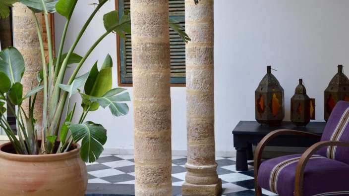 Ein Wohnzimmer mit einem lila Stuhl und einer Pflanze