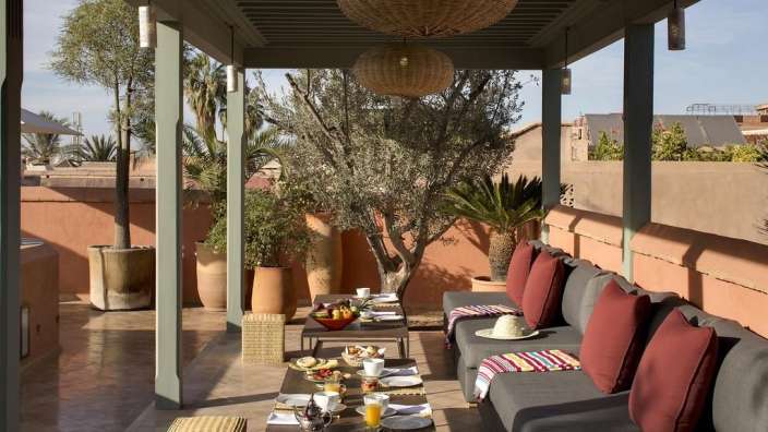 Eine Terrasse mit Couchgarnituren und einem Tisch mit Essen darauf