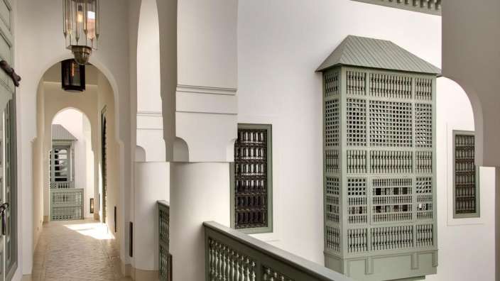 Ein weißes Gebäude mit vielen Fenstern und einer Laterne