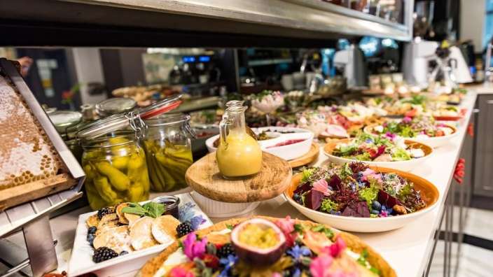 Ein Buffettisch mit vielen Tellern und Gläsern mit Essen