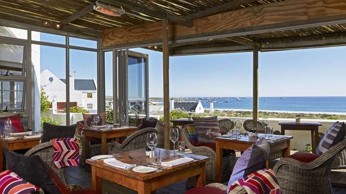 Tische und Stühle in einem Restaurant mit Blick auf das Meer