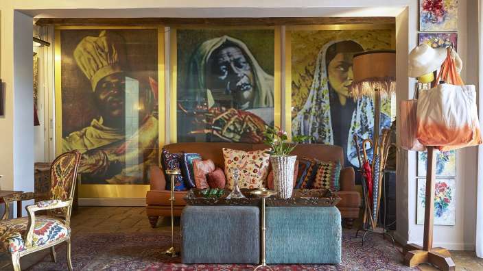 Ein Wohnzimmer mit vielen Gemälden an der Wand