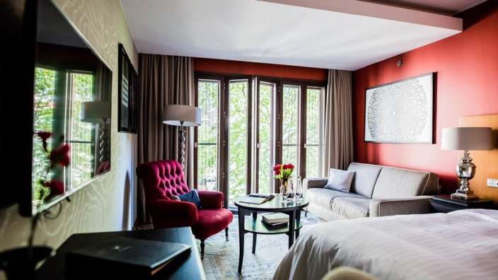 Ein Hotelzimmer mit roten Wänden und einem roten Stuhl