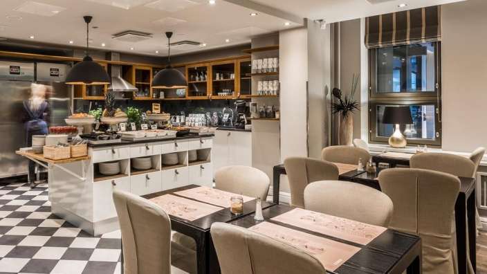 Ein Esszimmer mit einem Tisch und Stühlen und einem Kühlschrank