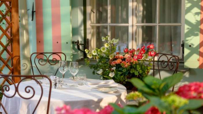 Ein Tisch und Stühle stehen vor einem gestreiften Gebäude