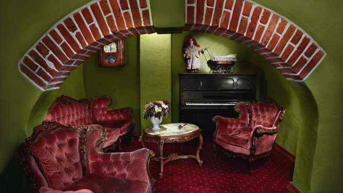 Ein Wohnzimmer mit roten Möbeln und einem Klavier