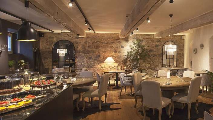 Ein Esszimmer mit vielen Tischen und Stühlen