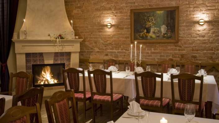 Ein Speisesaal mit einem Kamin und einem Gemälde an der Wand