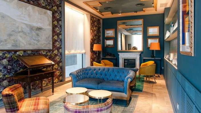 Ein Wohnzimmer mit einem blauen Couch und gelben Stühlen