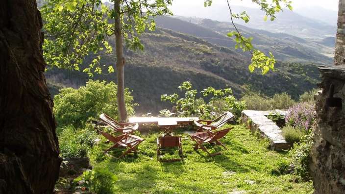 Ein Tisch und Stühle auf einer Wiese mit Blick auf die Berge