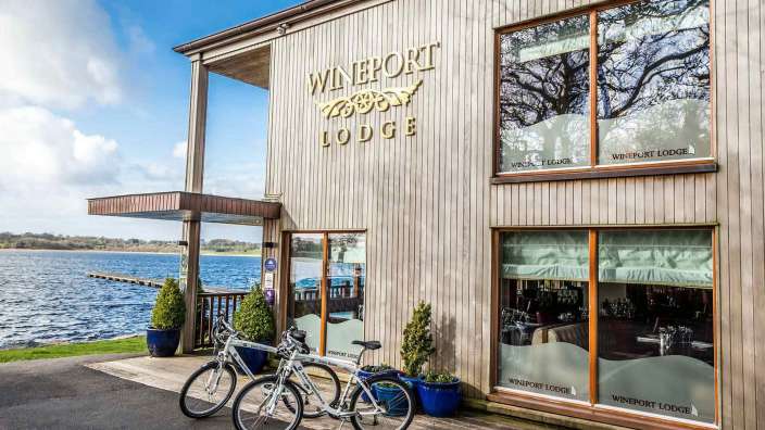Zwei Fahrräder stehen vor einem Holzgebäude mit der Aufschrift " wineport lodge "